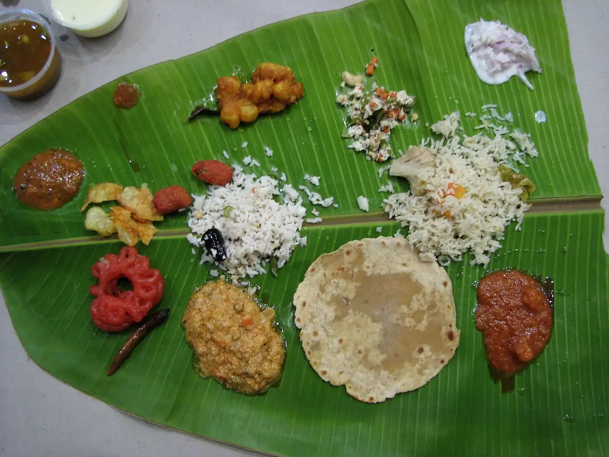 A South Indian wedding lunch served on a banana leaf, seen from above